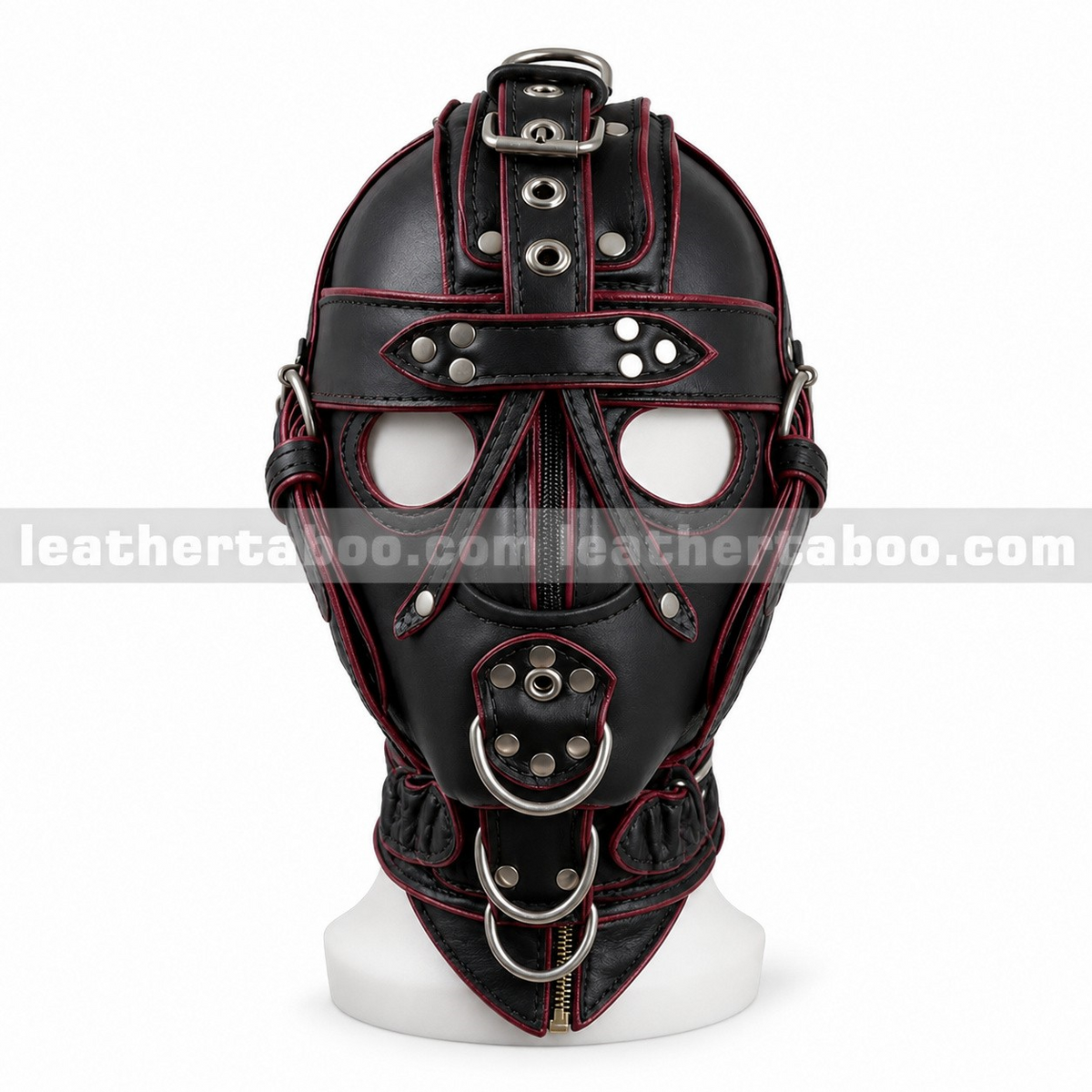 Front view of black leather harness hood with red trim, round eye openings, covered mouth panel, riveted straps and metal rings on a white mannequin.