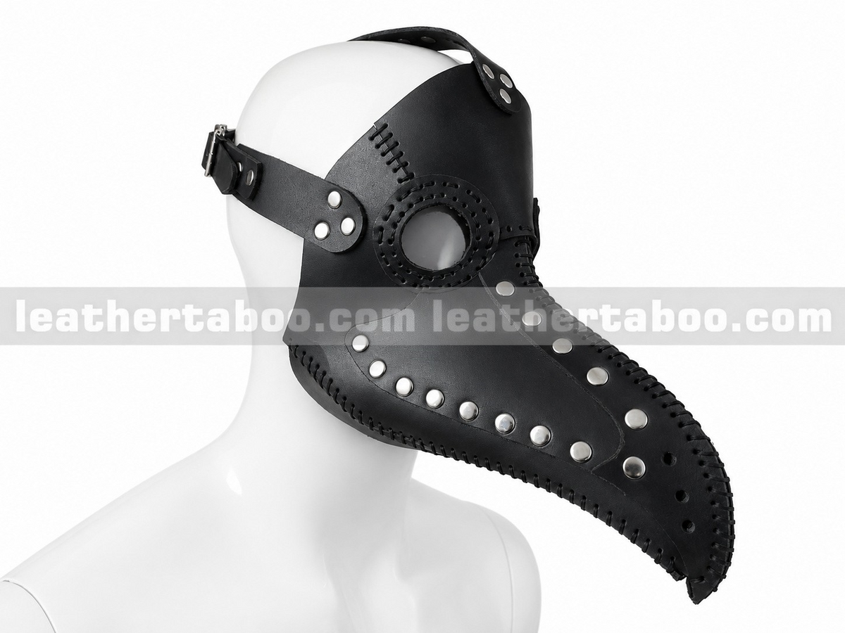 Angled view of black leather plague doctor mask with long curved beak, round eye openings, silver-tone rivets and edge lacing on a white mannequin.