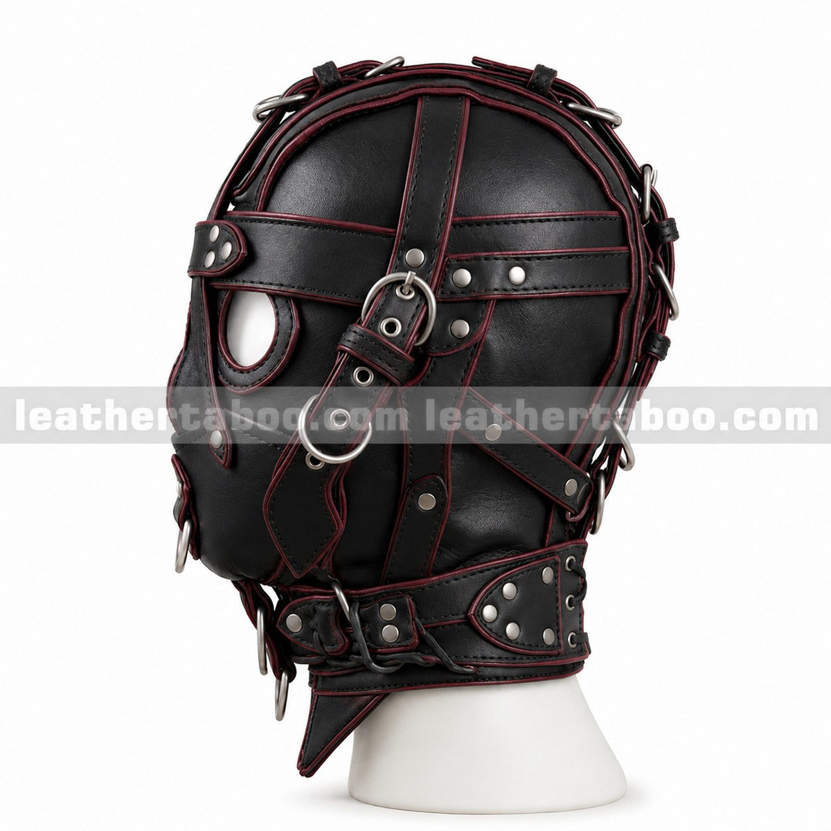 Side view of black leather harness hood showing red edging, layered buckle straps, eye opening and wide riveted collar on a white mannequin.