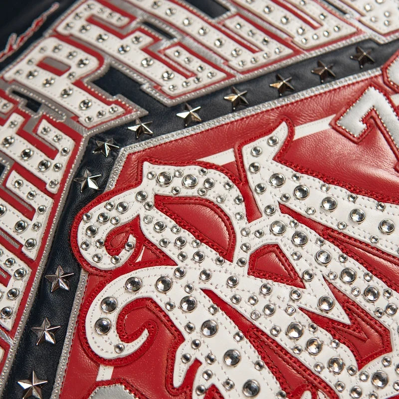 Close-up of red and white leather artwork on the navy Pelle Pelle All Time Champions Jacket, with round embellishments and star studs.